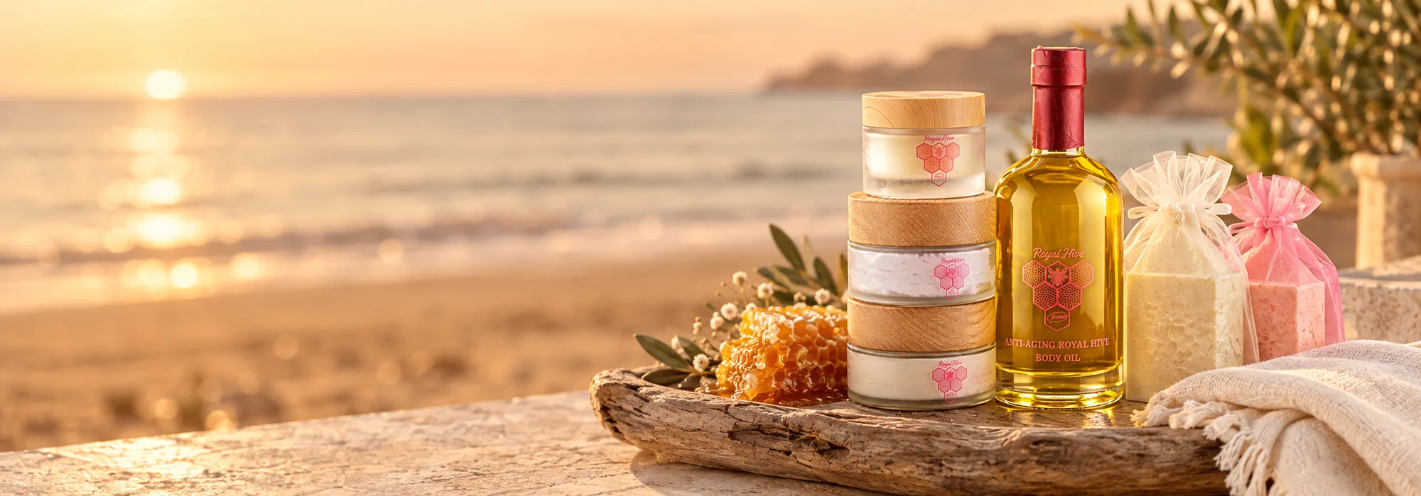 Royal Hive skincare collection on a driftwood tray overlooking the beach at golden hour