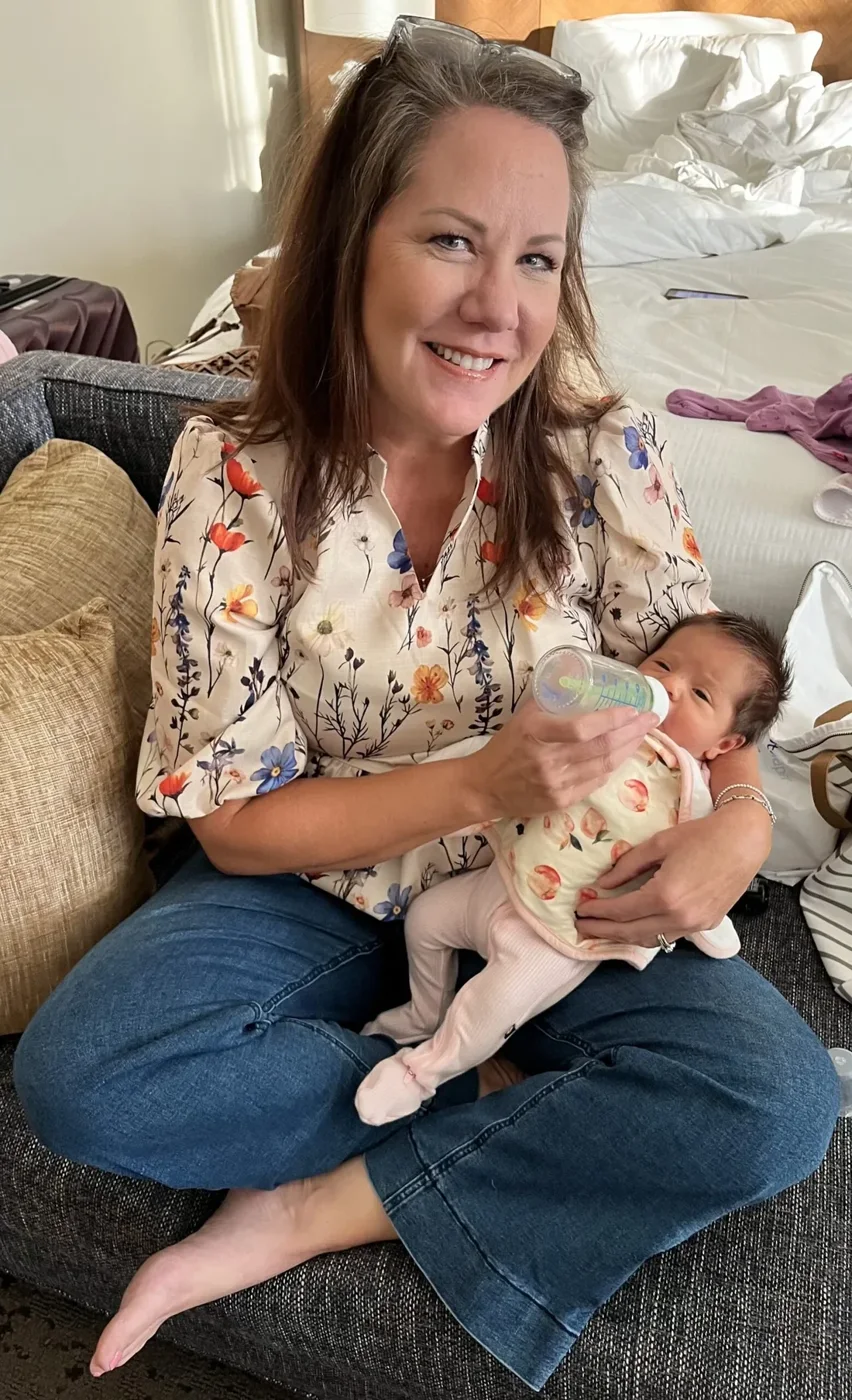 SimpleFix weight loss patient before treatment, sitting on a couch holding her grandchild